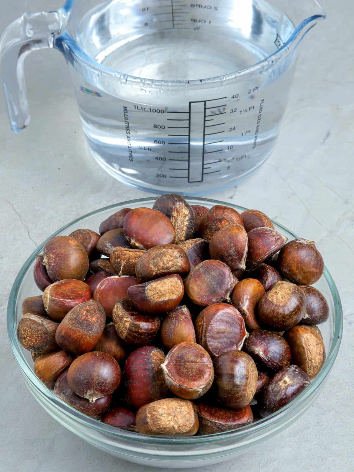 chestnuts in a bowl and water in a measuring cup