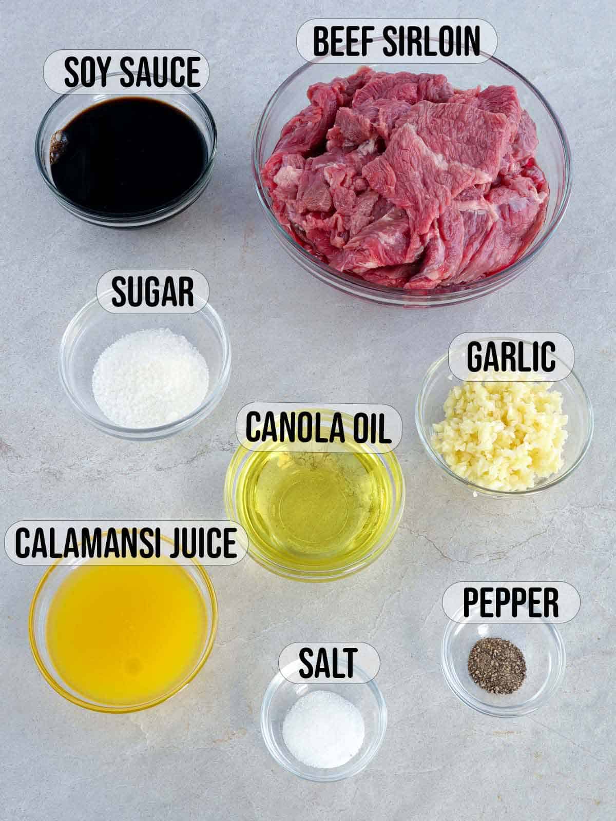 sliced beef, calamansi juice, soy sauce, sugar, salt, pepper, oil, and garlic in bowls.