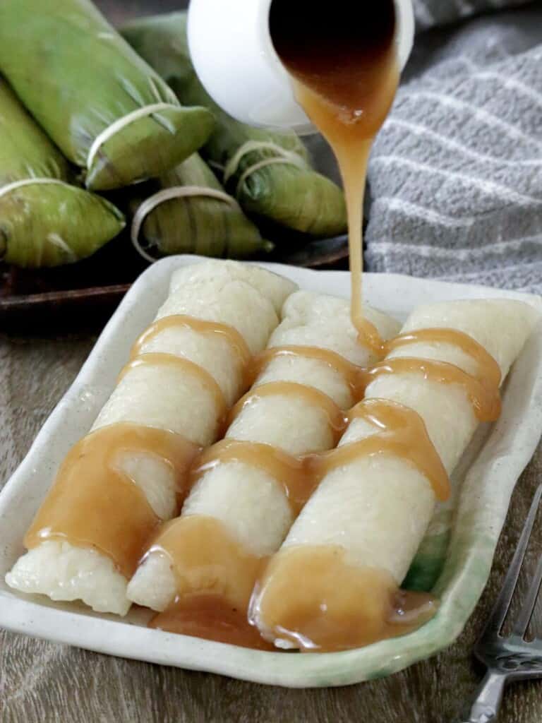 suman malagkit drizzled with coconut caramel sauce on a serving plate