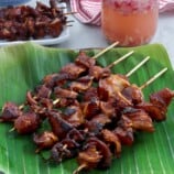 BBQ Pork Ears on a banana leaf lined plate with spicy vinegar on the side