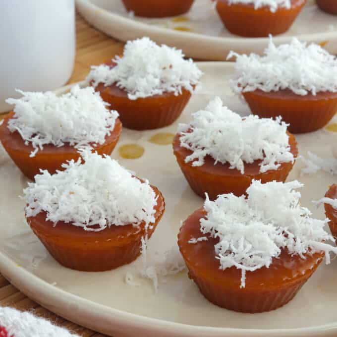 kutsinta with grated coconut topping on white plates.