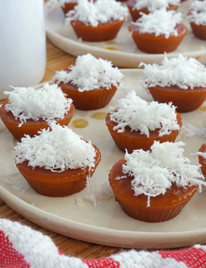 kutsinta with grated coconut topping on white plates.