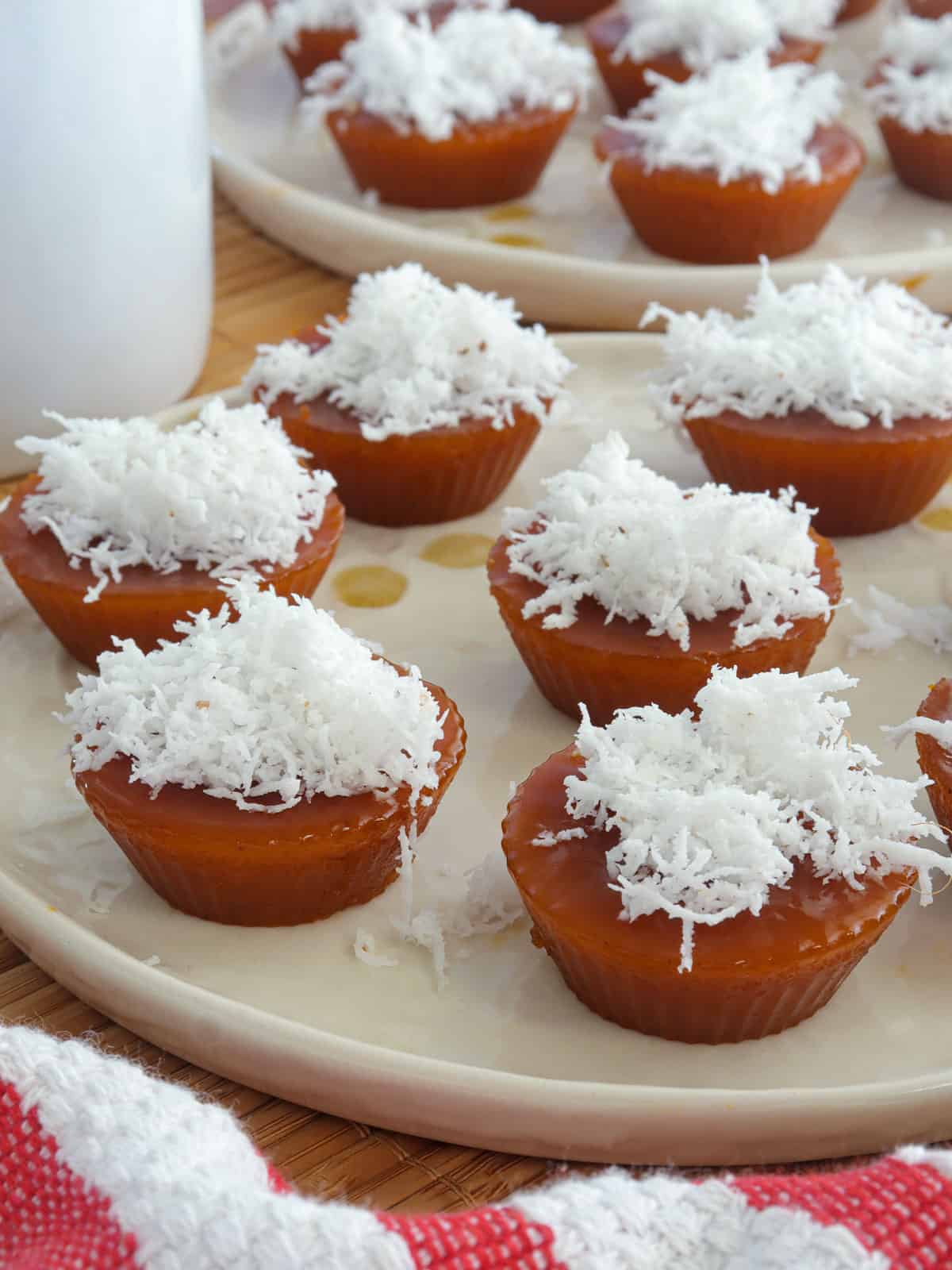 kutsinta with grated coconut topping on white plates.