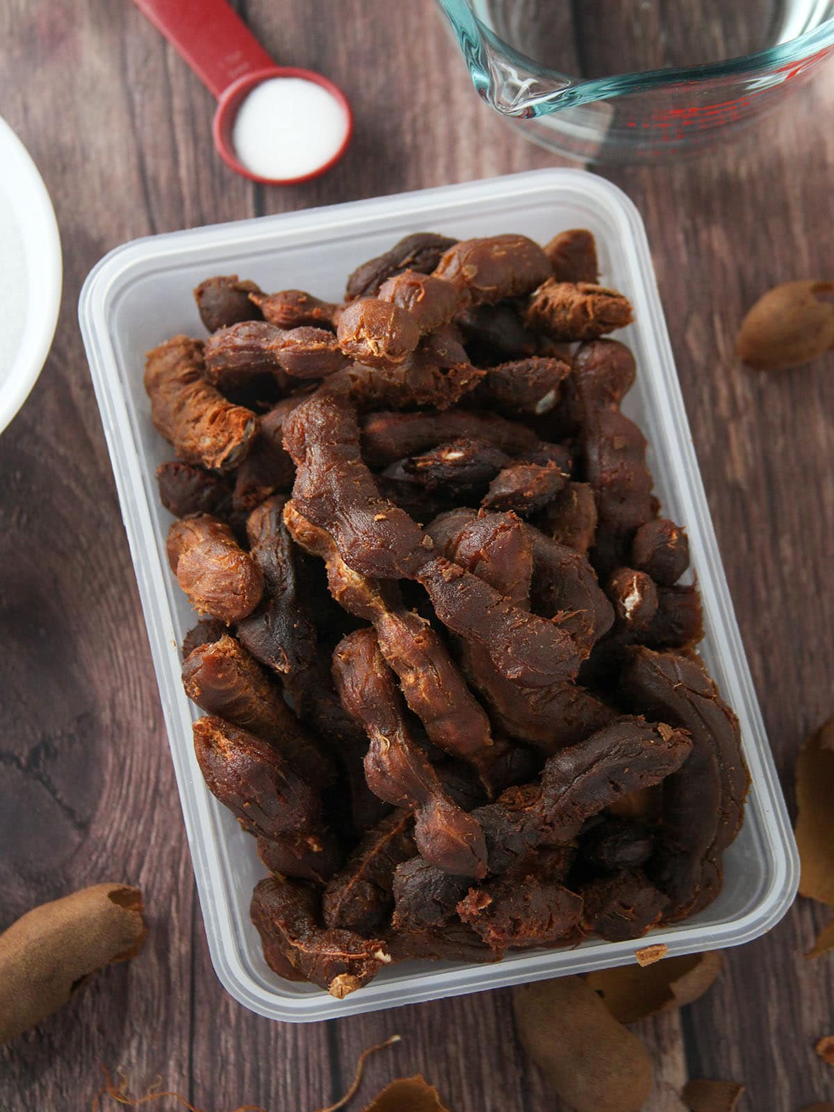 peeled tamarind pods in a plastic container