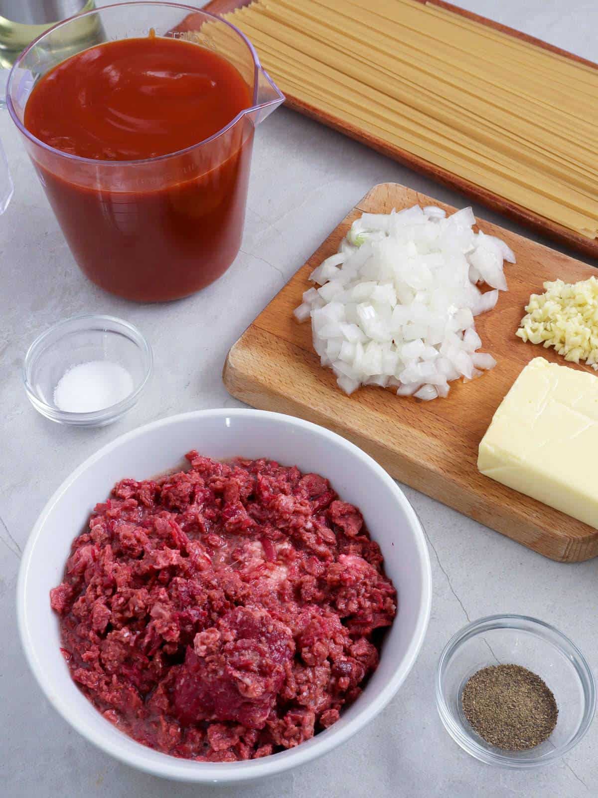 canned corned beef, spaghetti sauce, spaghetti noodles, chopped onions, and minced garlic