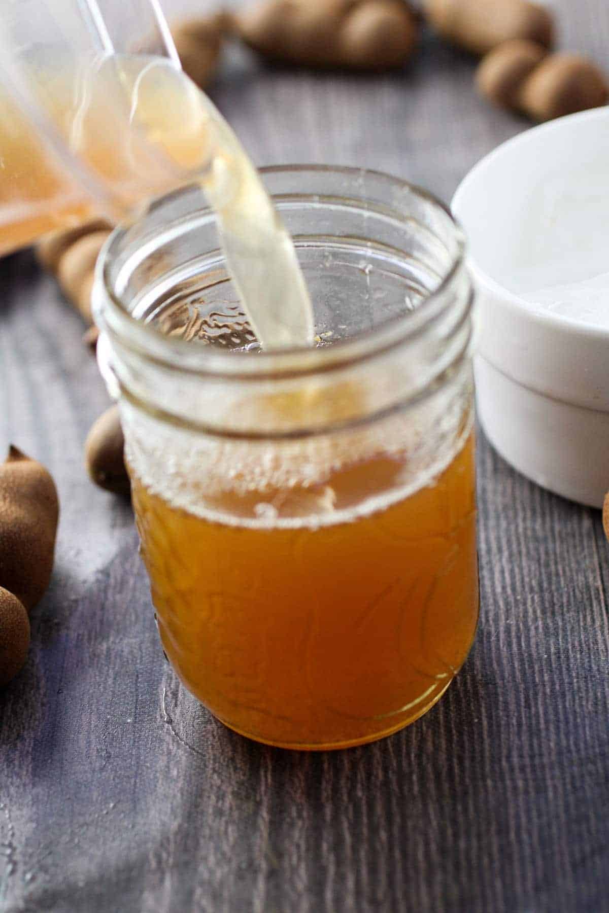 pouring tamarindo in a clear glass