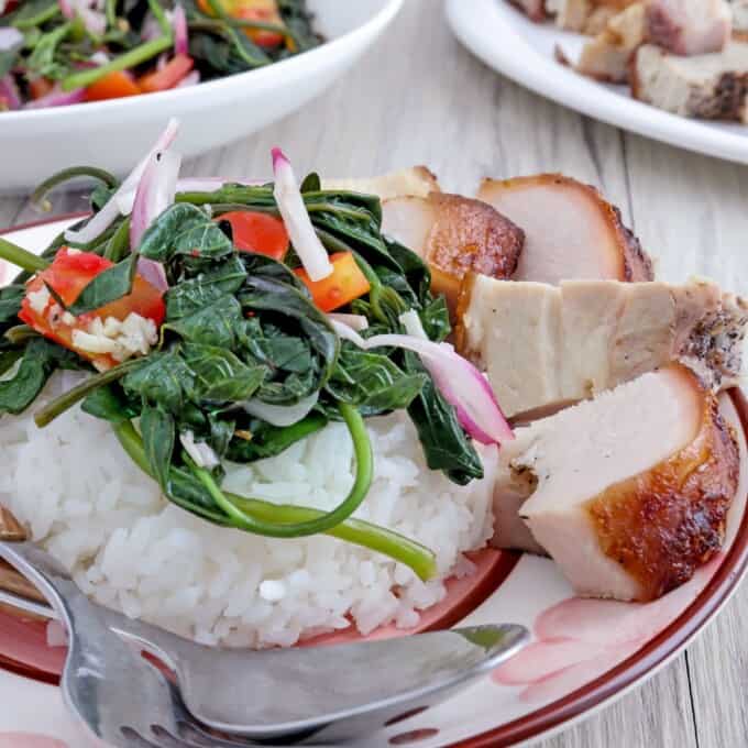 Sweet potato leaves salad over steamed rice with lechon kawali on the side