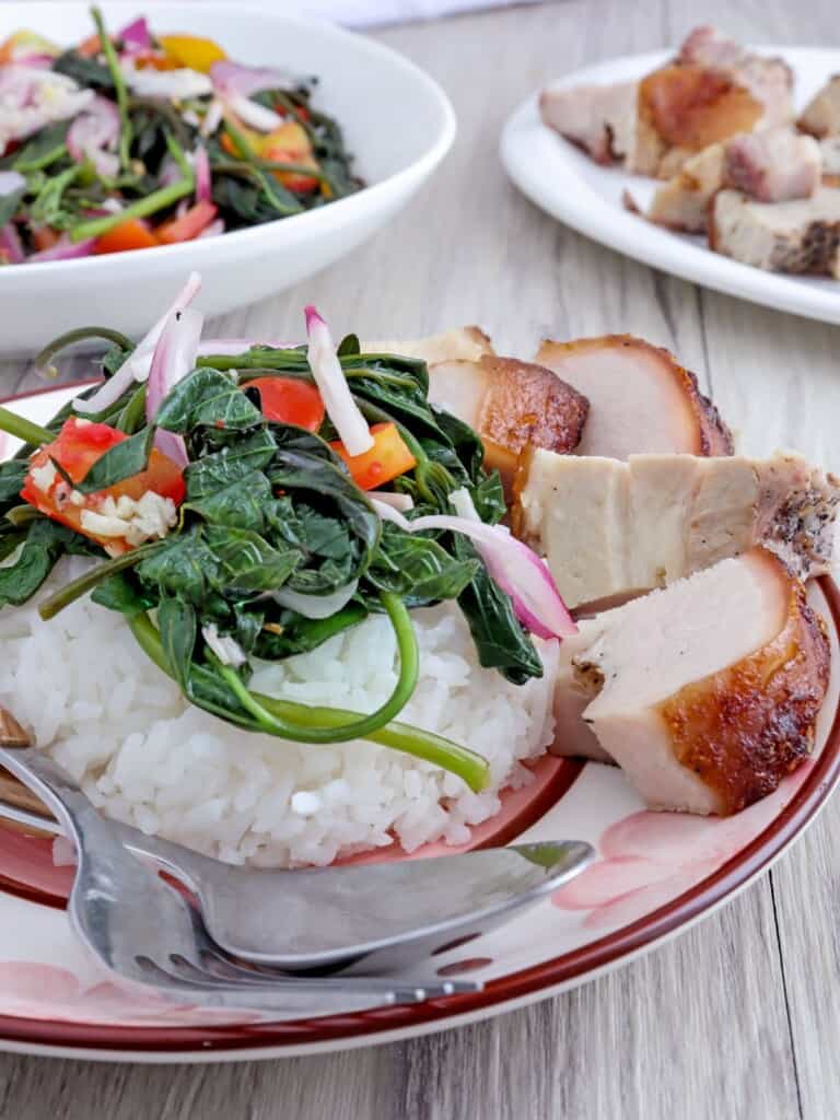 kamote tops salad over steamed rice with lechon kawali on the side