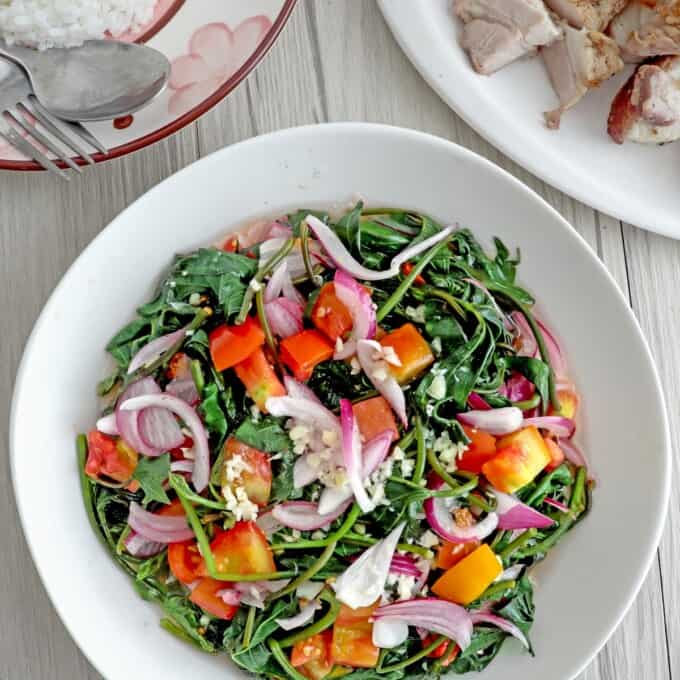 Ensaladang Talbos ng Kamote in a serving bowls with steamed rice and lechon kawali on the side