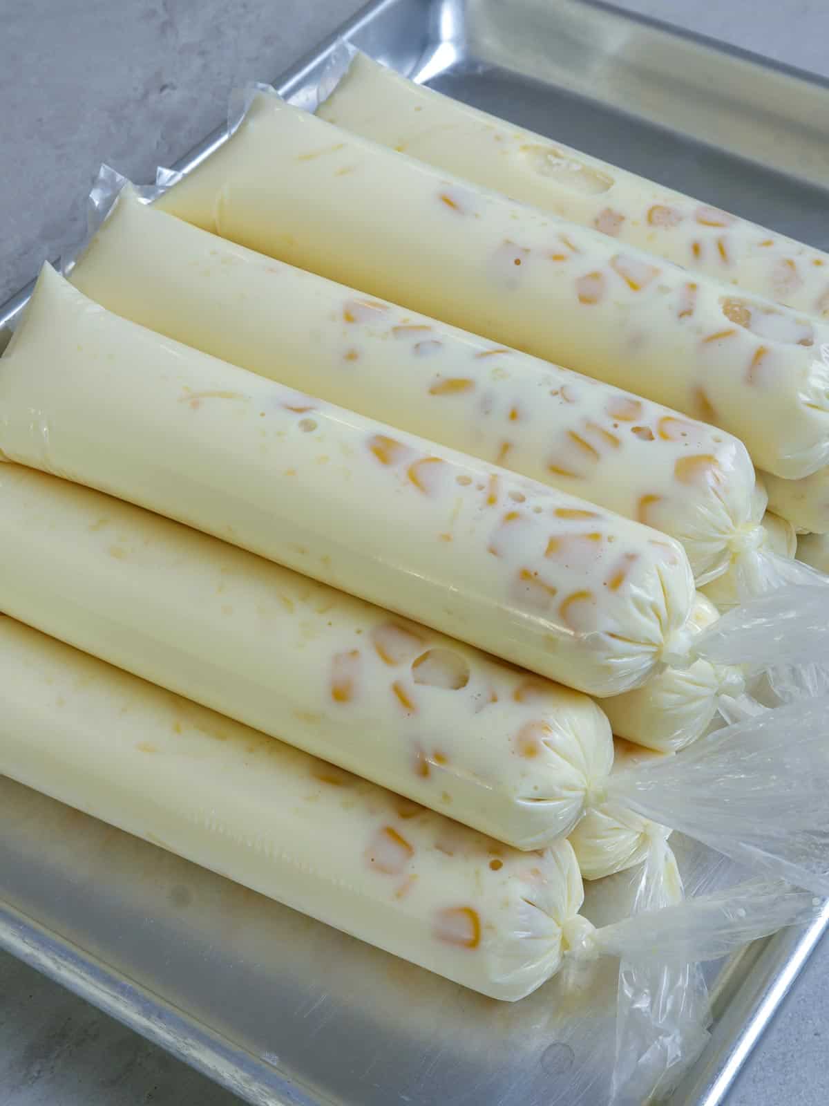 mais con queso ice candies on an aluminum tray ready to freeze.