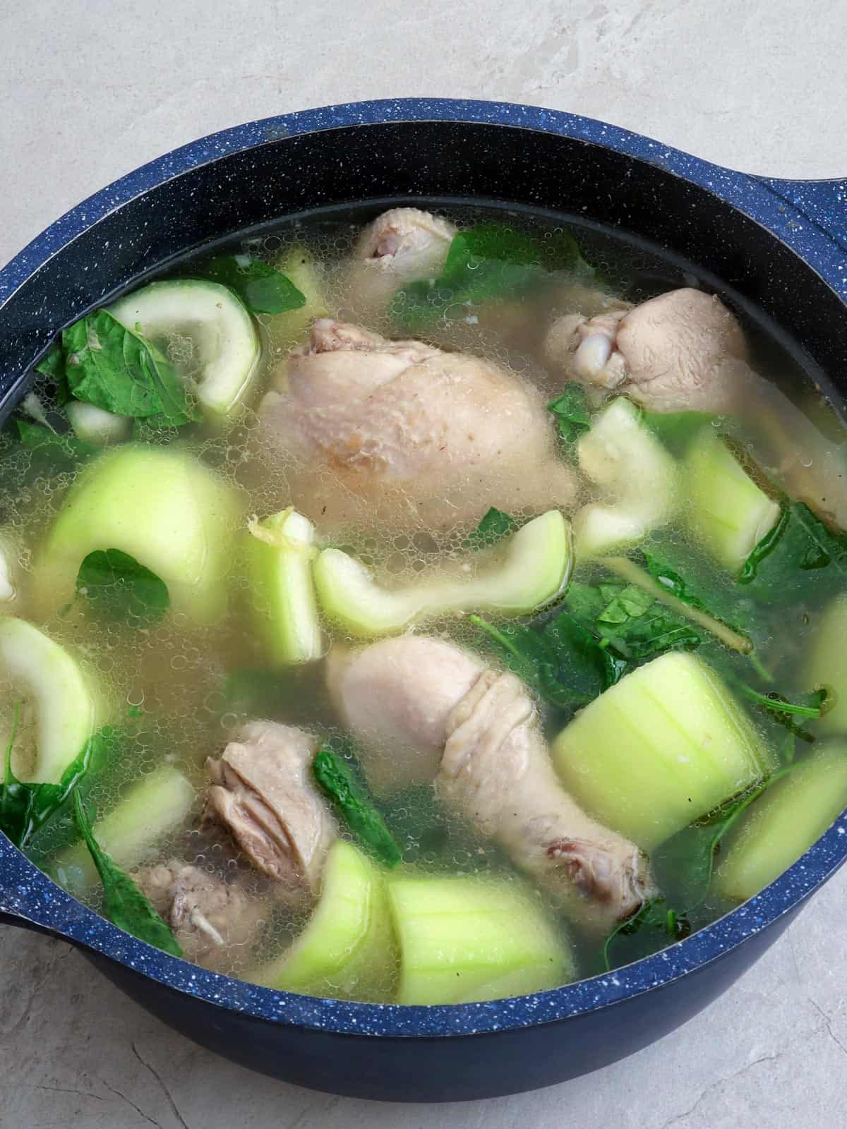 chicken tinola with upo and spinach in a pot