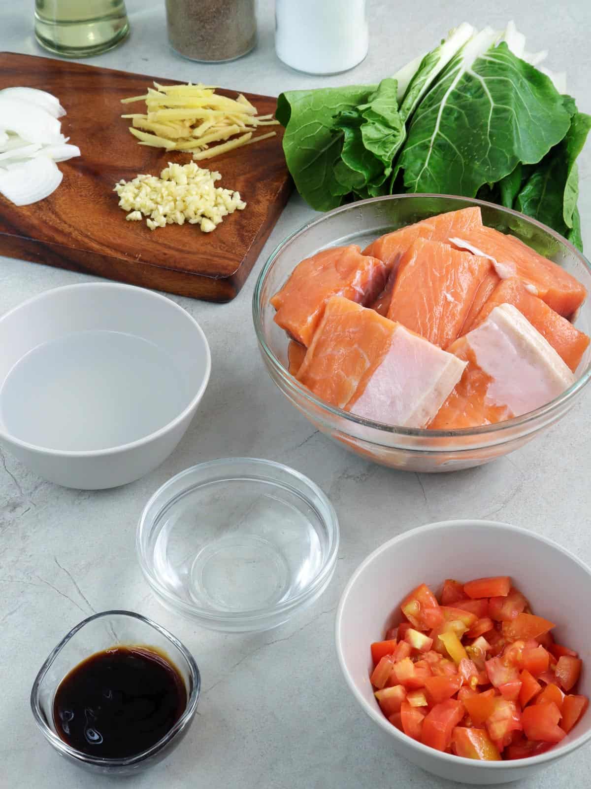 salmon bellies, chopped tomatoes, pechay, vinegar, oyster sauce, ginger, onions, and garlic