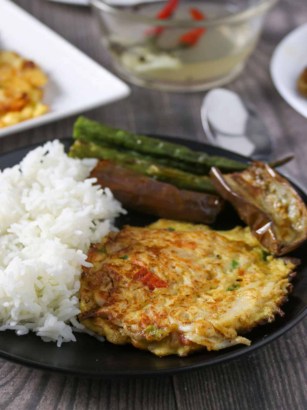 Tortang Dulong on a serving plate with fried eggplant and steamed okra on the side