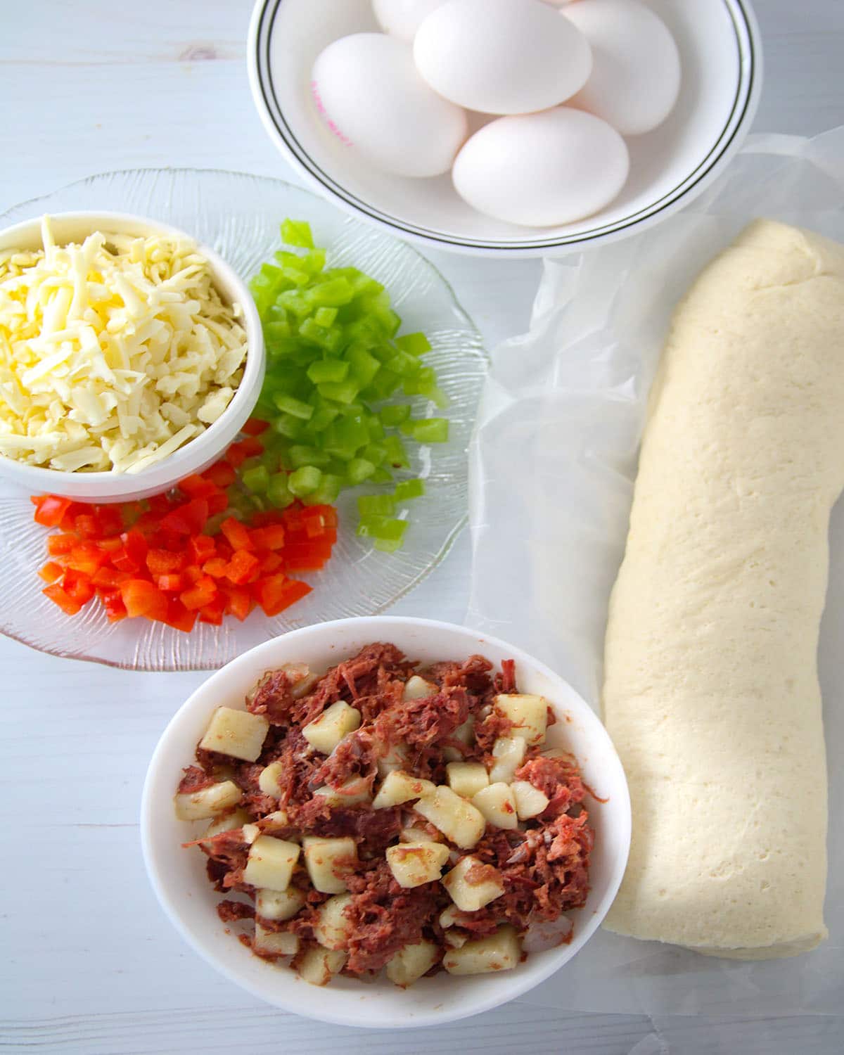 corned beef hash, shredded cheese, pizza dough, chopped bell peppers, eggs