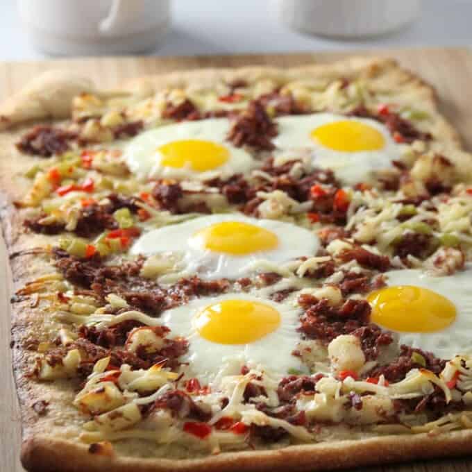 Corned Beef Hash Breakfast Pizza on a wooden board