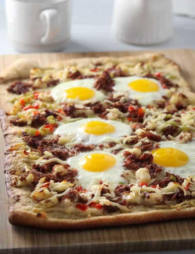 Corned Beef Hash Breakfast Pizza on a wooden board