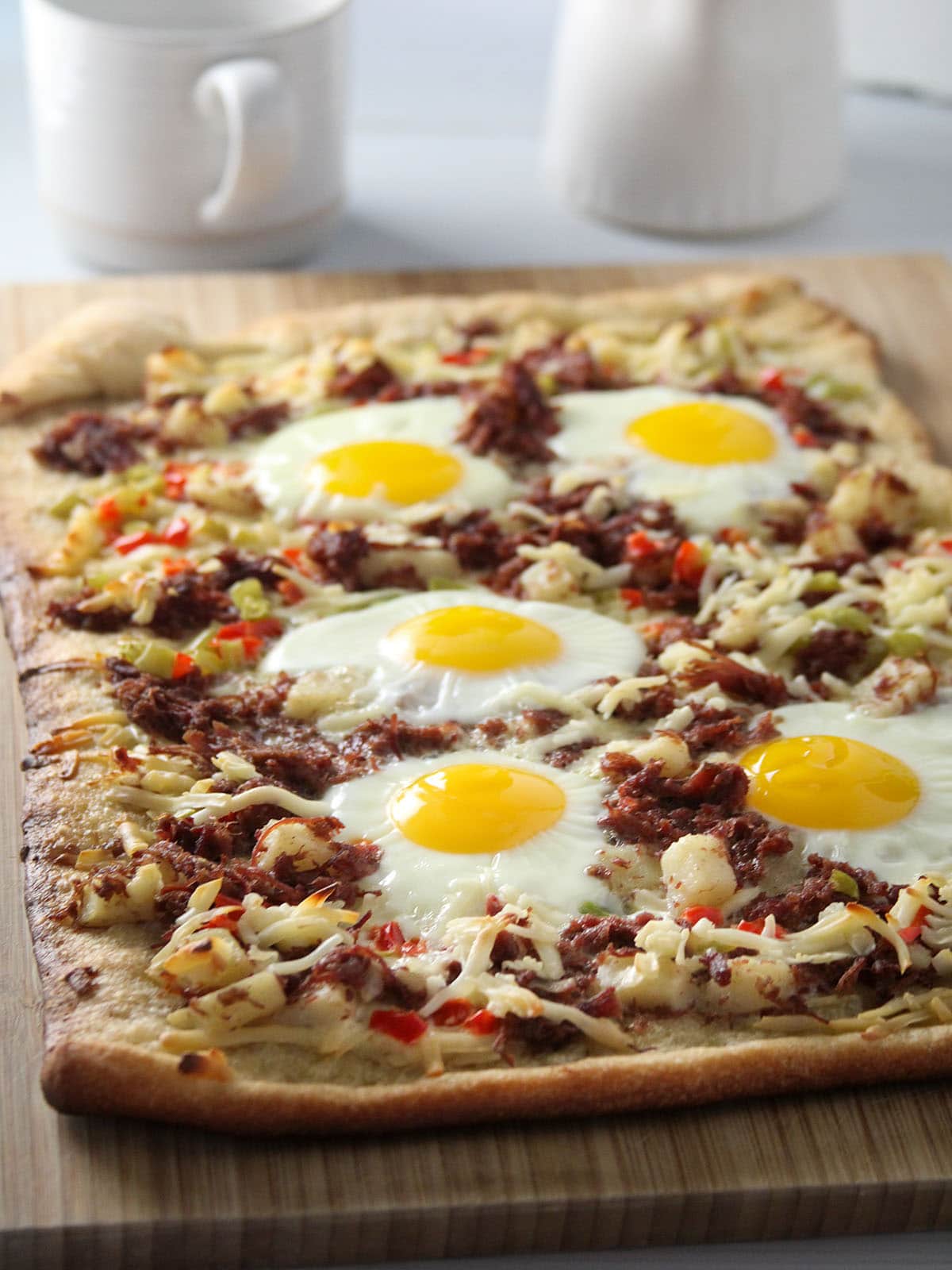 Corned Beef Hash Breakfast Pizza on a wooden board