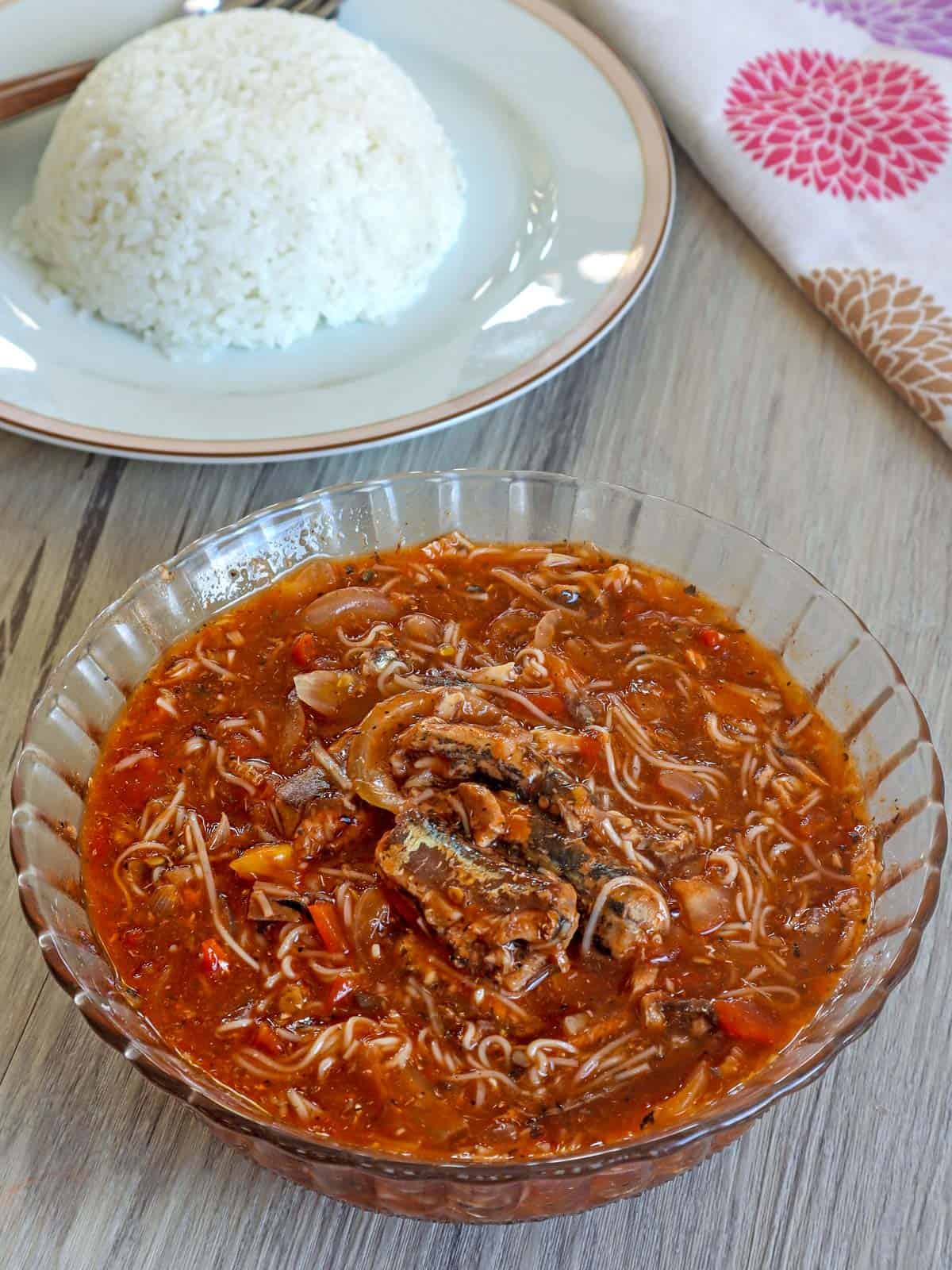 Ginisang Sardinas at Miswa in a clear bowl with a plate of steamed rice on the side