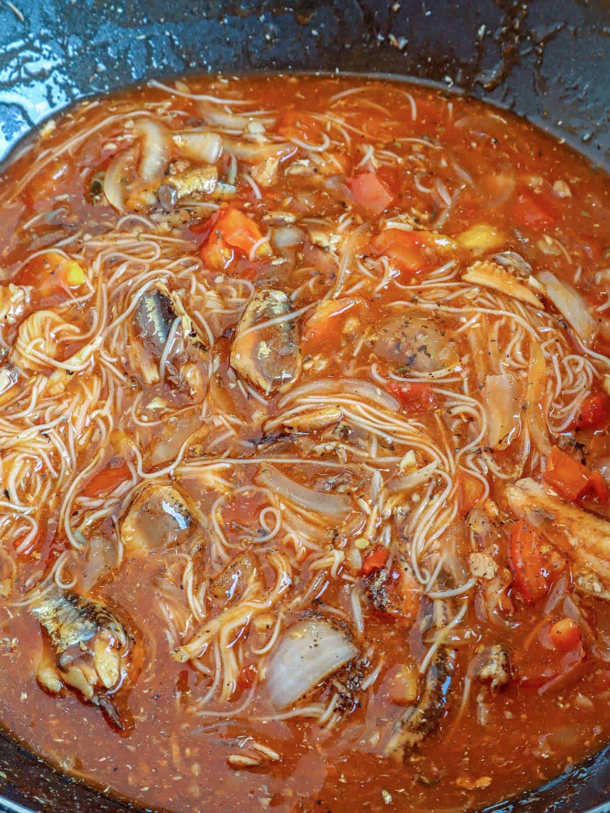 cooking ginisang sardinas with misua in a pan