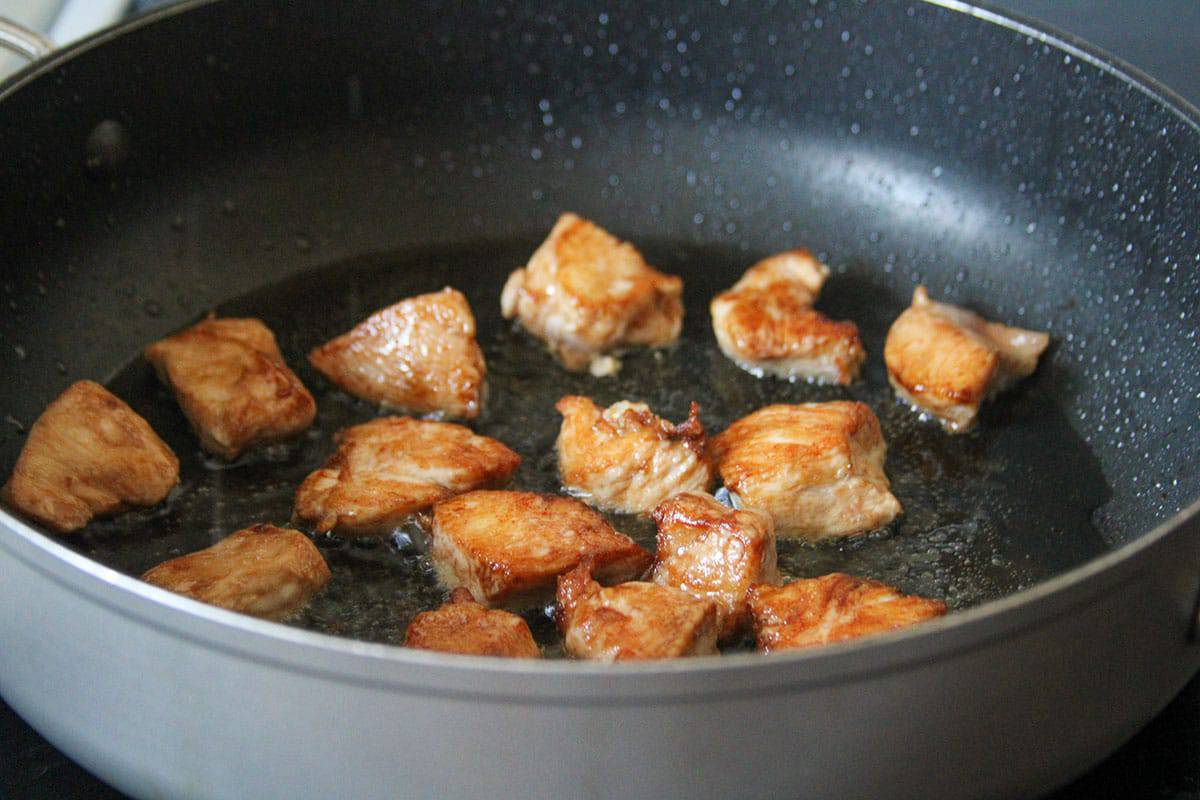 browning chicken breast cubes in a wide pan