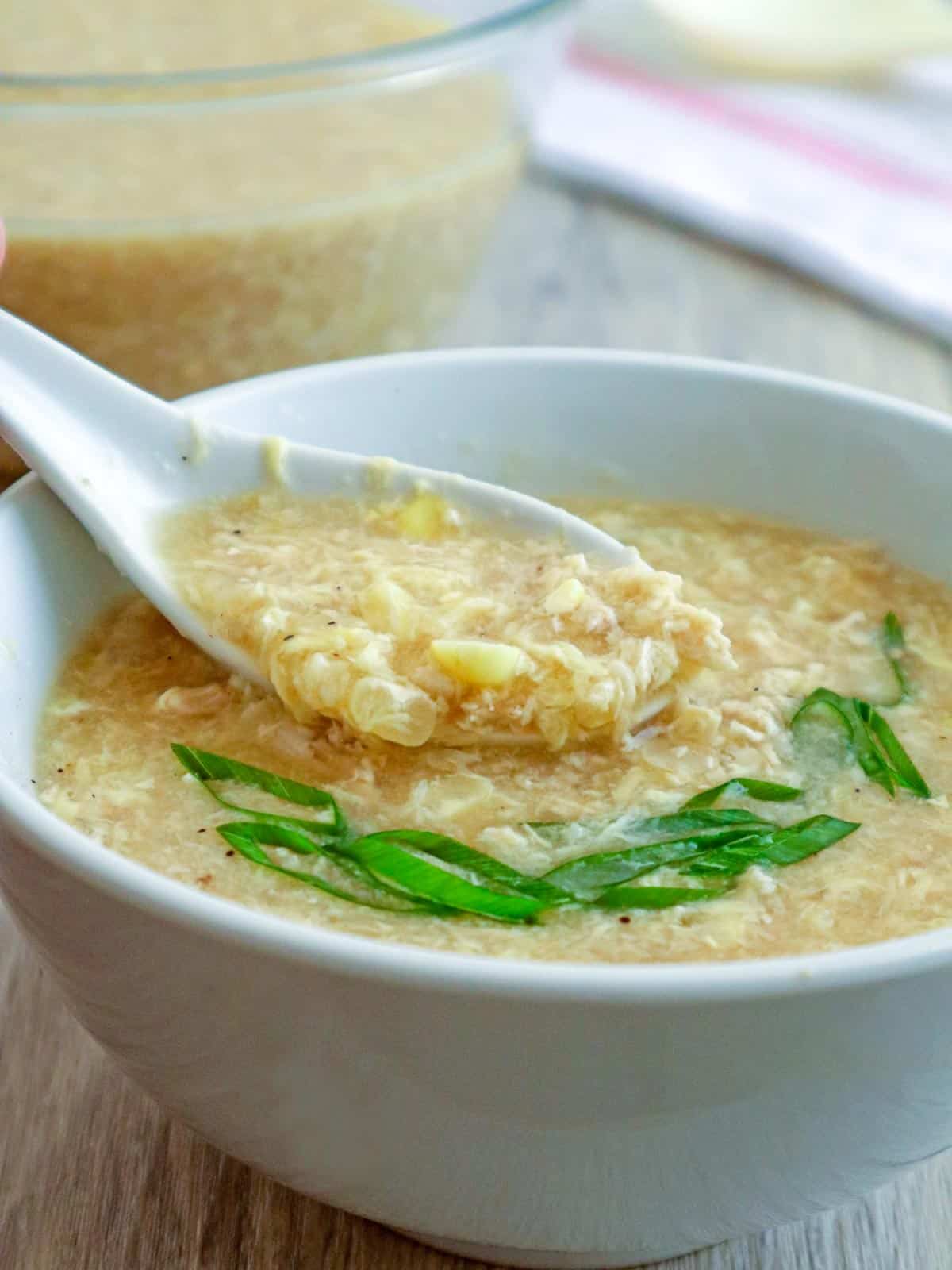 eating Chicken Corn Soup from a white bowl