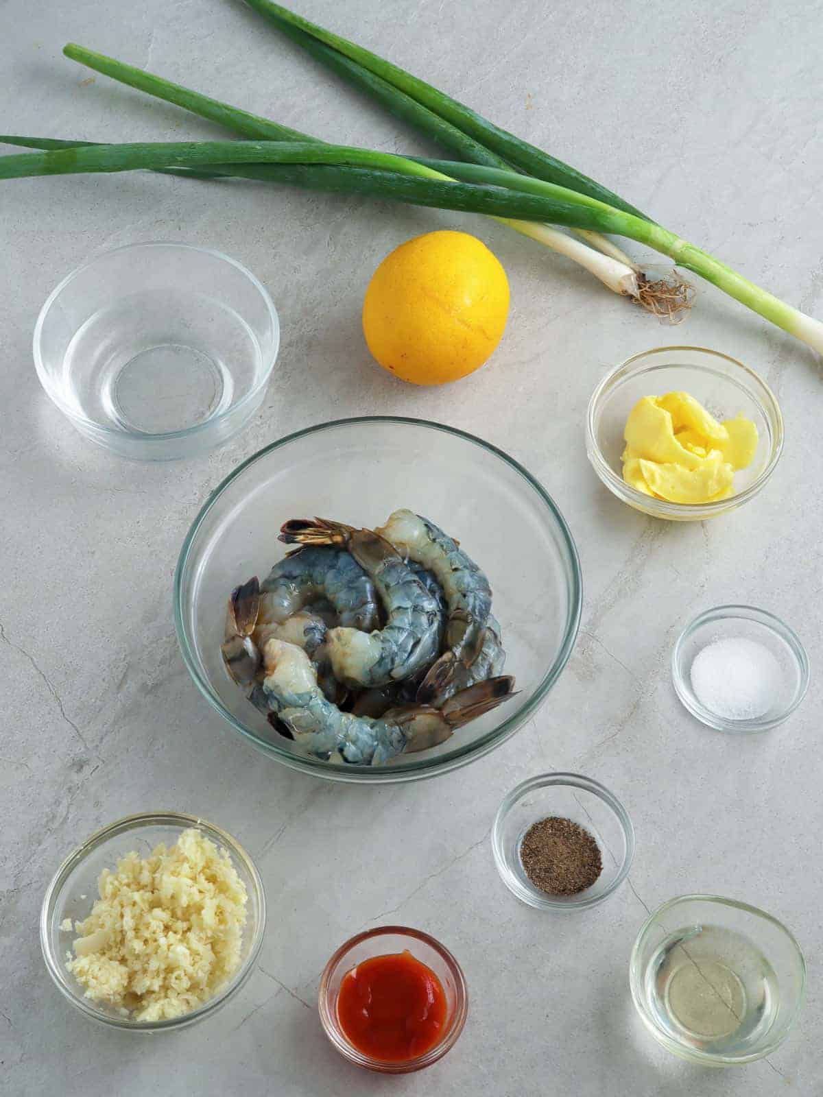 peeled shrimp, lemon, green onions, minced garlic, salt, pepper, sriracha sauce in individual bowls