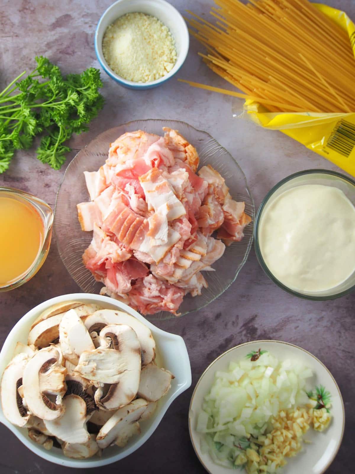 sliced bacon, mushrooms, chopped onions, garlic, spaghetti, chicken, broth, heavy cream, parmesan cheese, and parsley