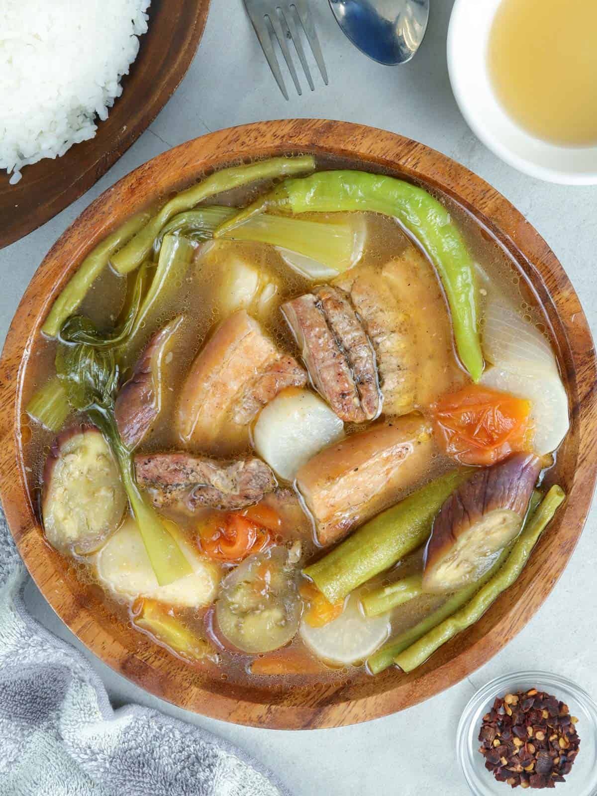 Sinigang na Inihaw na Liempo in a wooden serving bowl