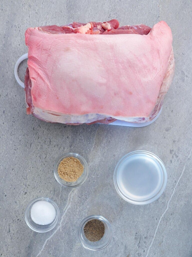 whole pork shoulder with skin, salt, pepper, vinegar, garlic powder