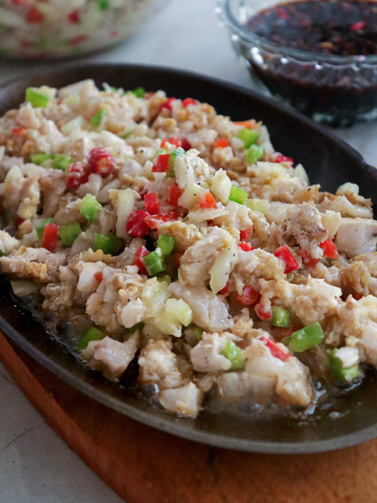 lechon kawali sisig on a sizzling cast iron plate