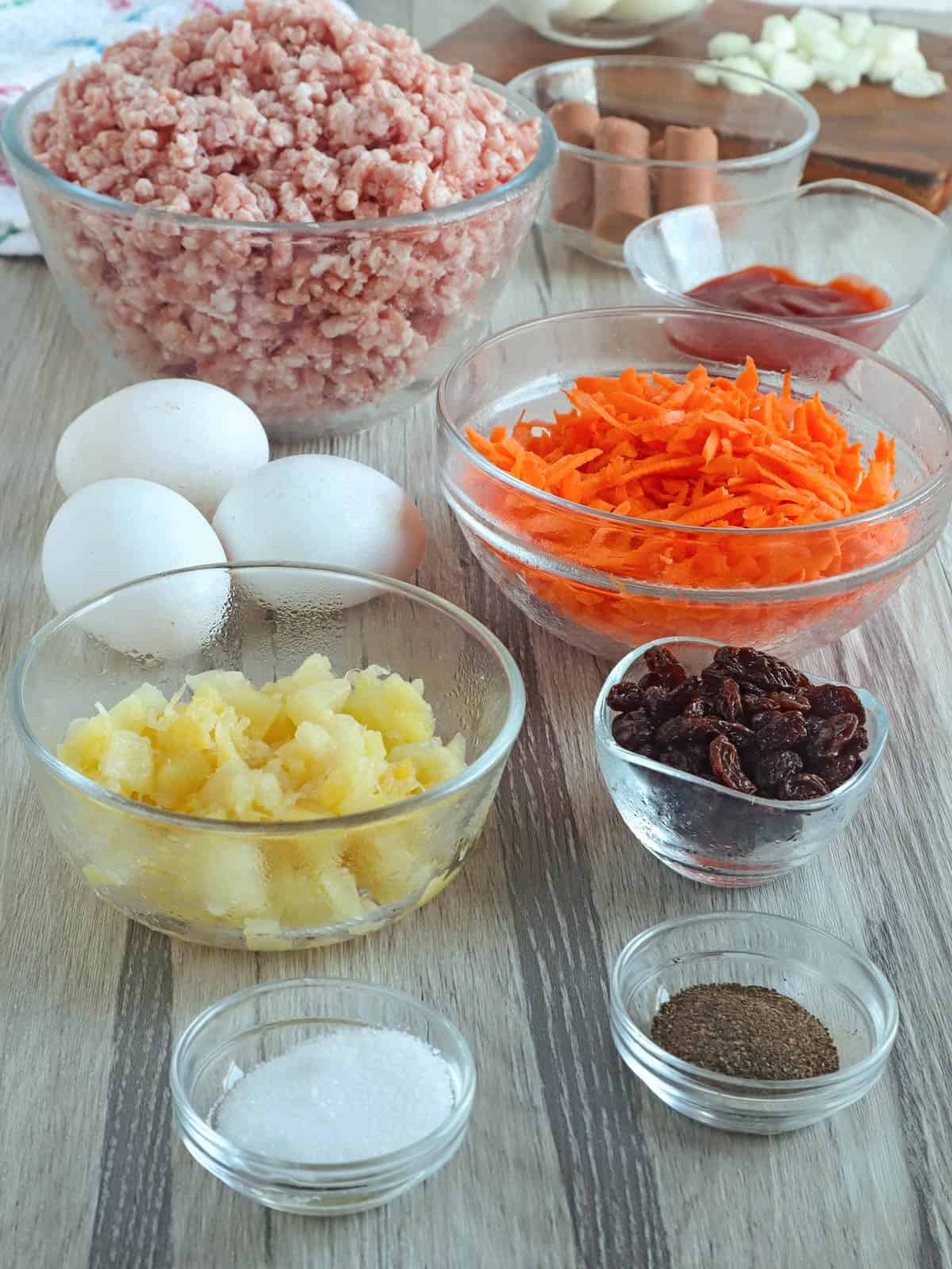 ground pork, shredded carrots, eggs, crushed pineapple, raisins, salt, pepper, banana ketchup, vienna sausages