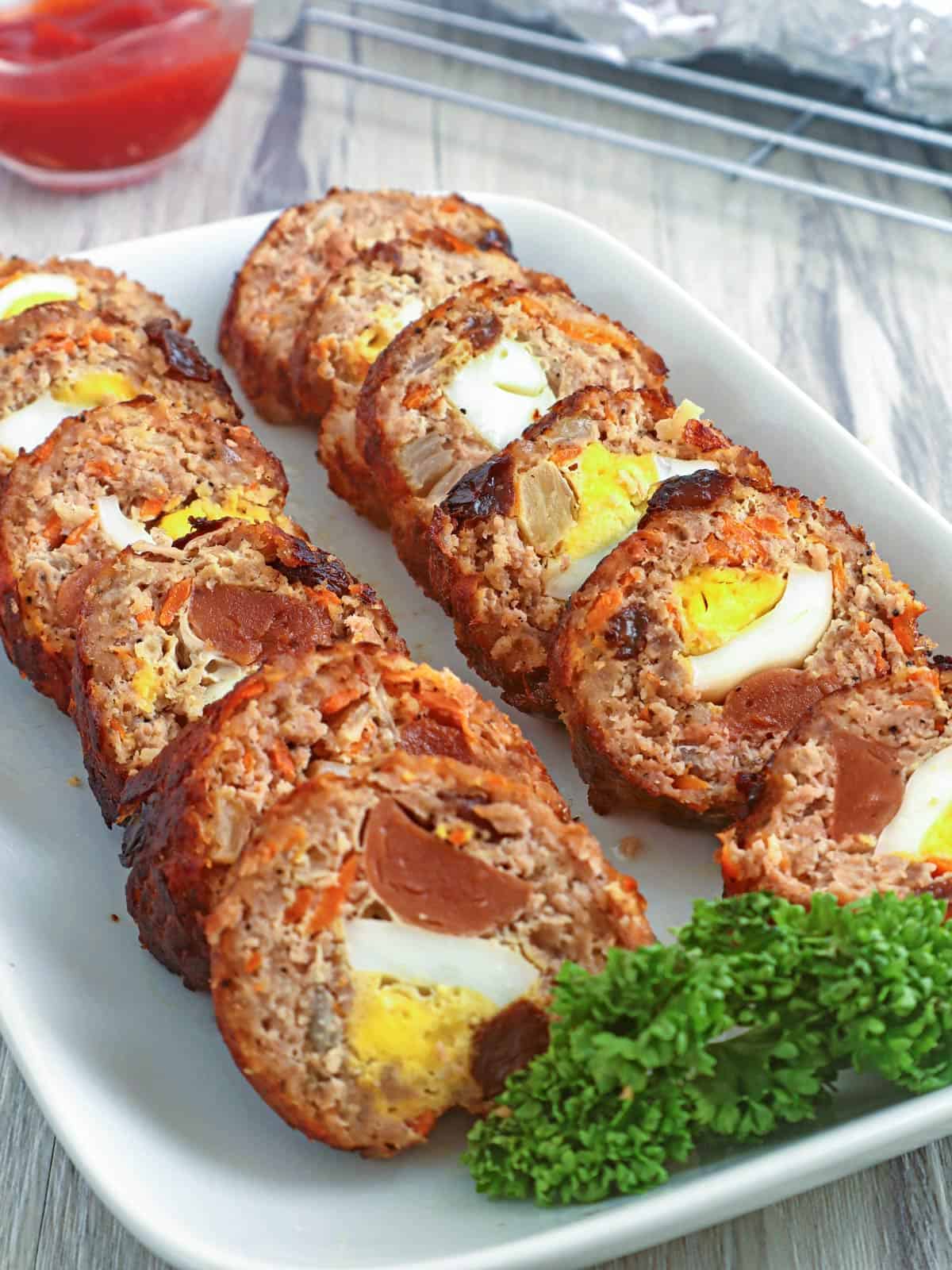 sliced embutido on a serving platter with a side of ketchup