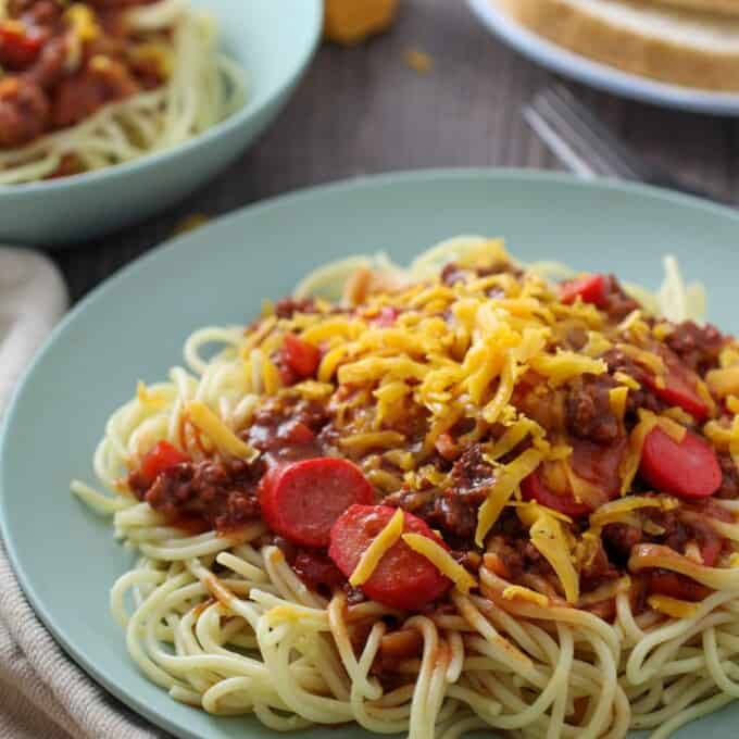 Filipino Spaghetti with hot dogs and grated cheese on a serving plate