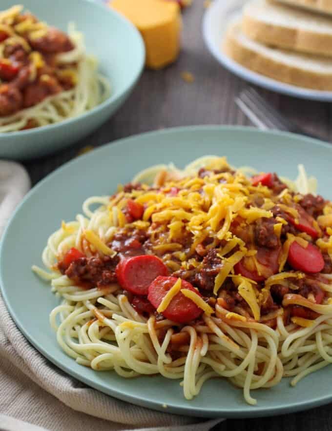 Filipino Spaghetti with hot dogs and grated cheese on a serving plate