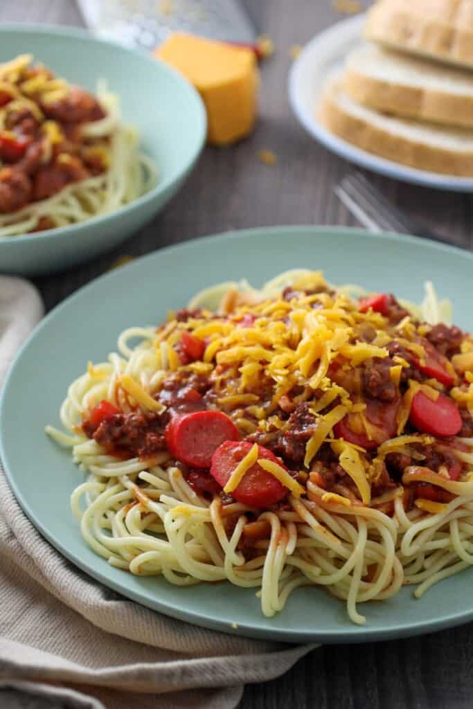 Filipino Spaghetti with hot dogs and grated cheese on a serving plate