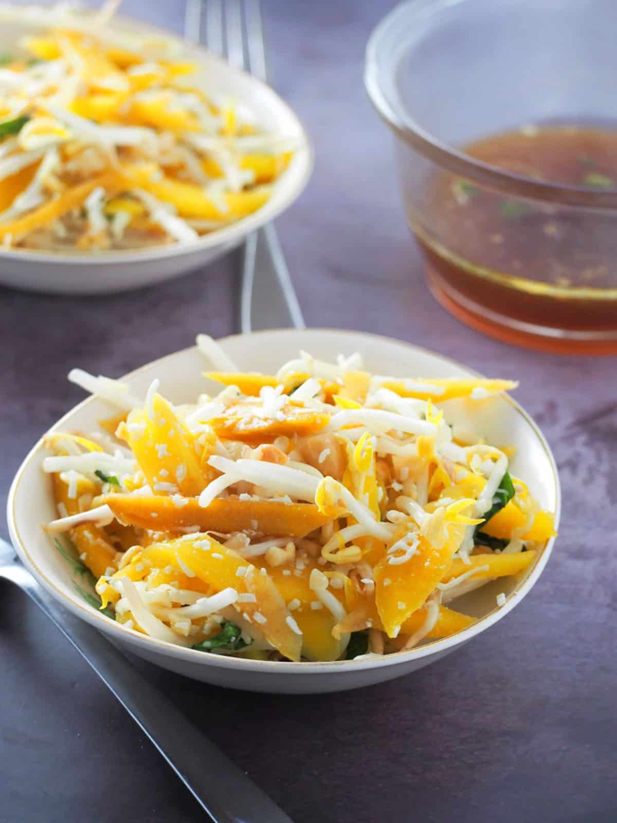 Thai mango salad in a white serving bowl