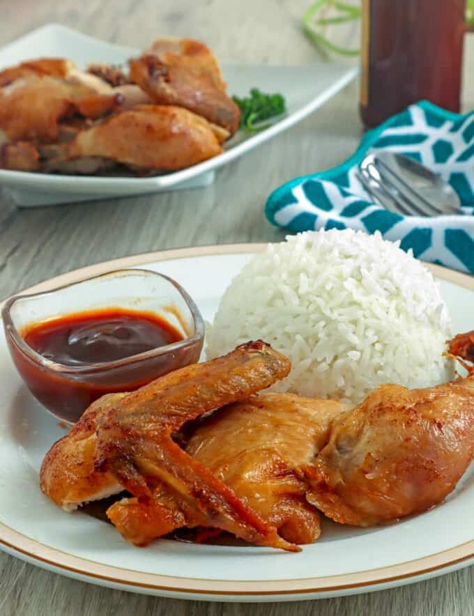 cut-up fried chicken with steamed rice on a white plate