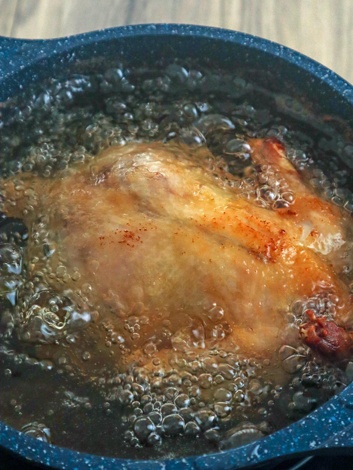 deep-frying chicken in hot oil in a pot