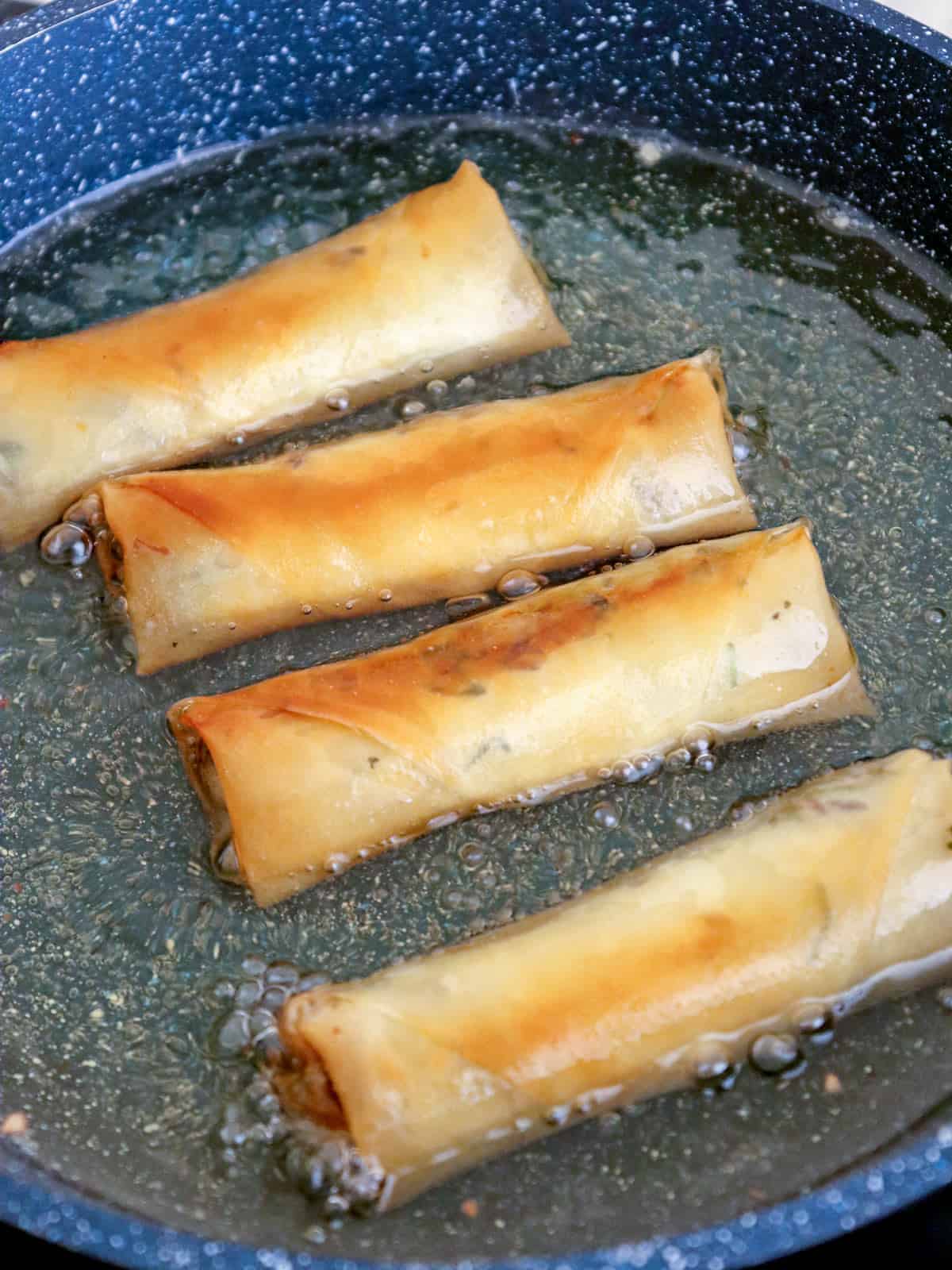 frying lumpiang galunggong in hot oil in a pan