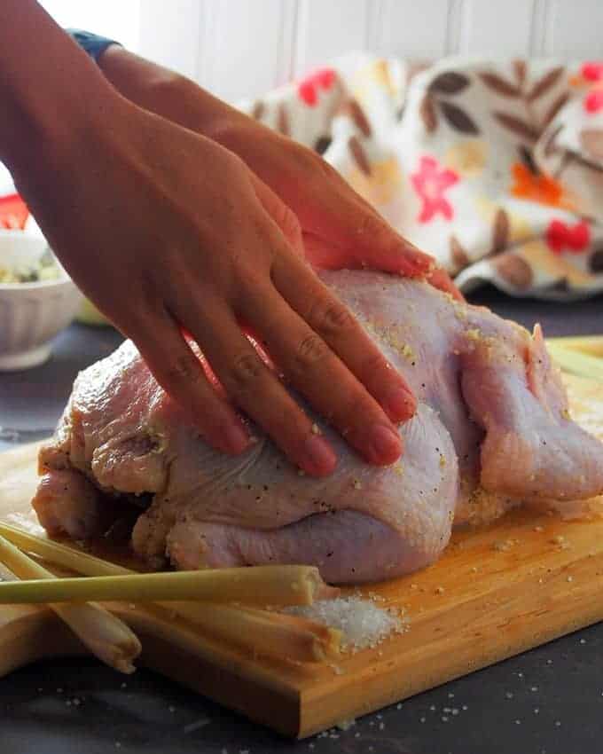 rubbing the whole chicken with salt and garlic mixture