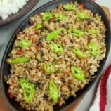 fish sisig on a sizzling cast iron plate