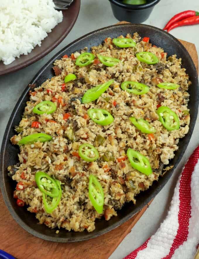 fish sisig on a sizzling cast iron plate