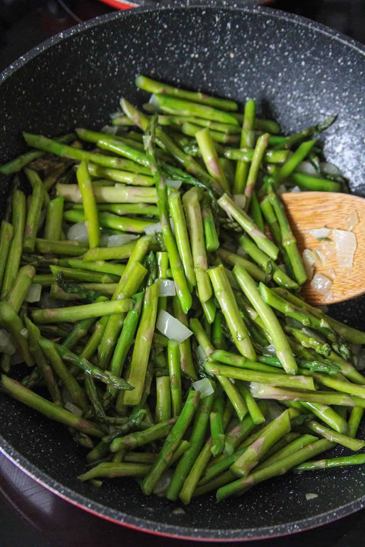 stir-frying asparagus in a wok