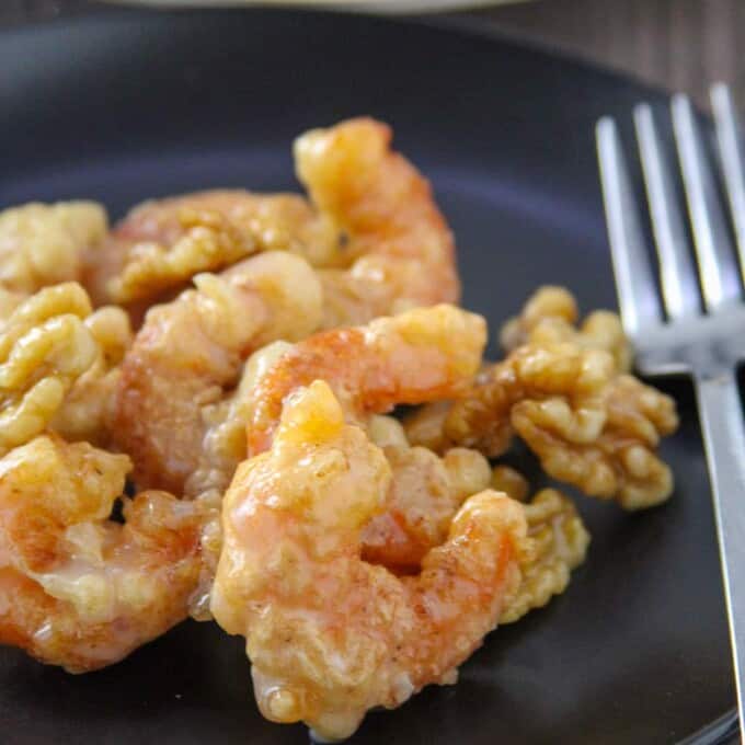 Honey Walnut Shrimp on a black serving plate with a fork