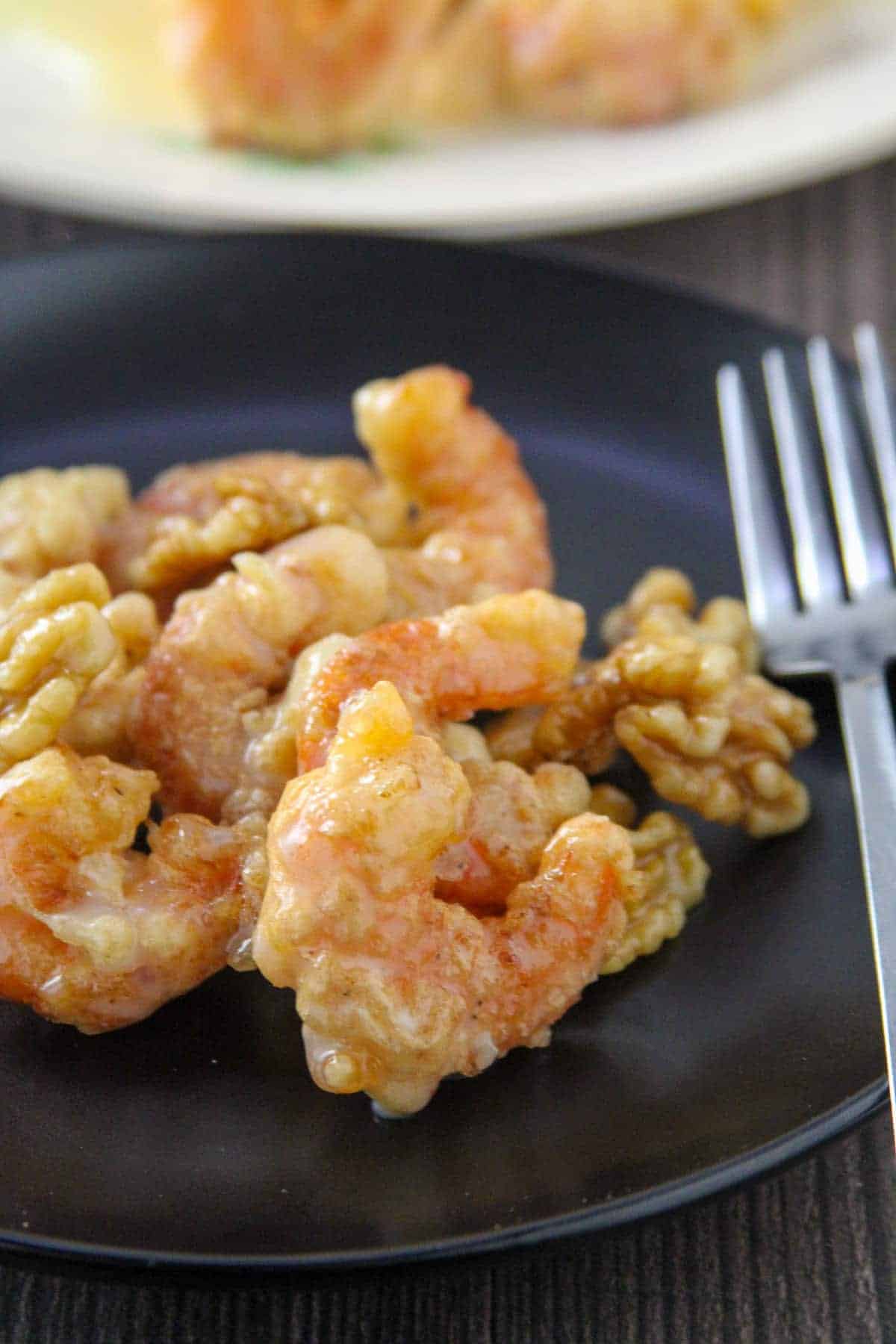 Honey Walnut Shrimp on a black serving plate with a fork