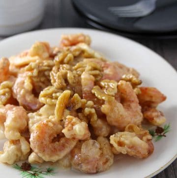 Honey Walnut Shrimp on a white plate with a bowl of rice on the side