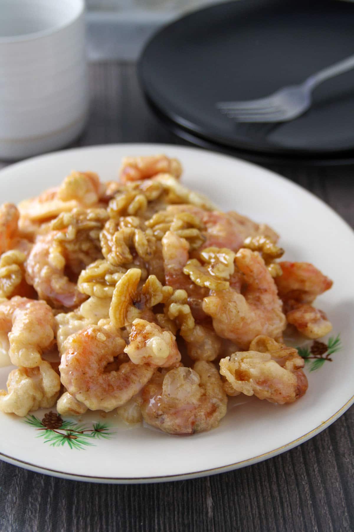 Honey Walnut Shrimp on a white plate with a bowl of rice on the side