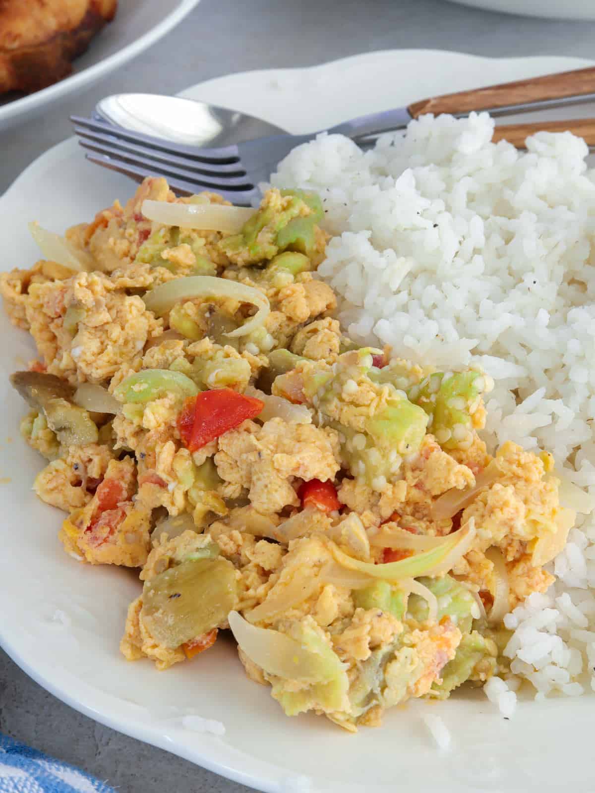 Poqui Poqui on a white plate with steamed rice and fork and spoon.