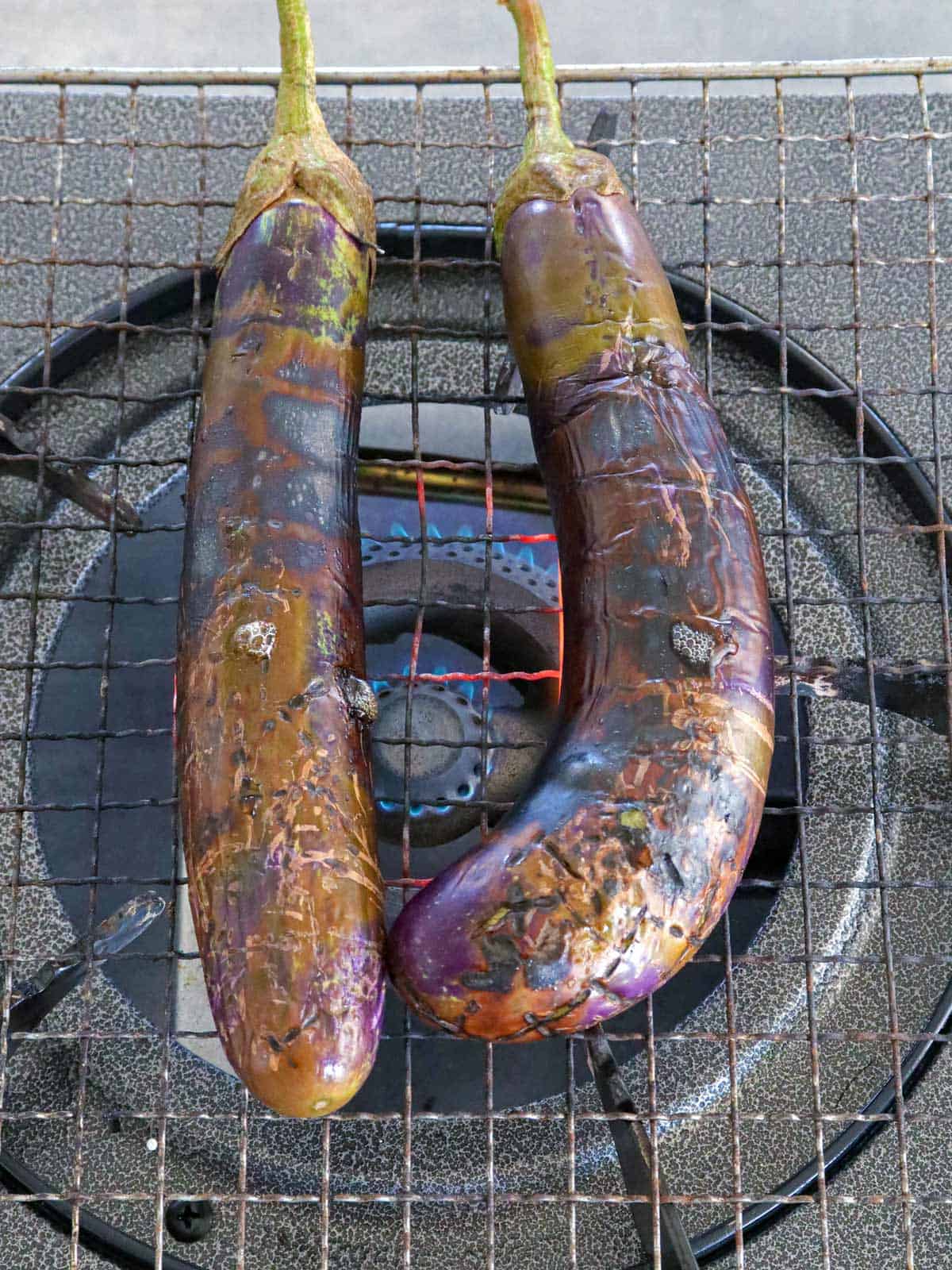 roasting eggplant on a wire rack on the stove.