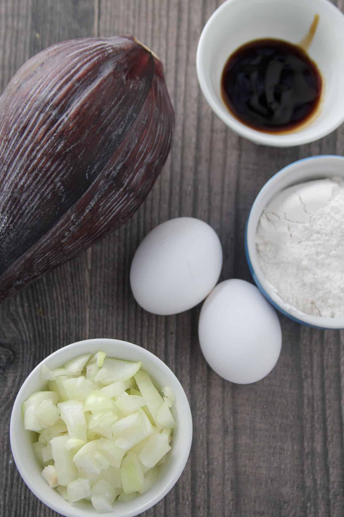 banana blossom, flour, eggs, onion, oyster sauce in bowls